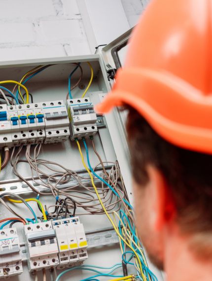 Commercial Electrician in Wheat Ridge, CO Looking at Wires