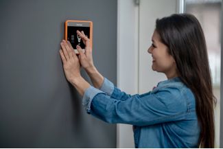 Woman in Westminster, CO Using a Panel After a Smart Home Electrical Installation
